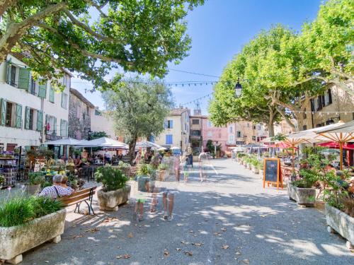 a street in a city with people sitting on benches at Holiday Home Maison de Village Les Ormeaux by Interhome in Tourtour