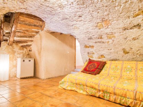 a bedroom with a bed in a stone wall at Holiday Home Maison de Village Les Ormeaux by Interhome in Tourtour