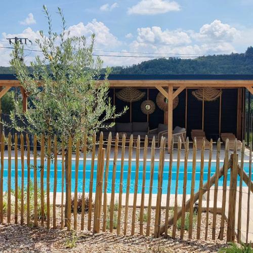 a fence in front of a house with a pool at Gîte, aux portes du Morvan in Voudenay-lʼEglise