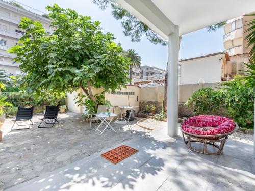 un patio extérieur avec un banc et un arbre dans l'établissement Apartment Les Girelles by Interhome, à Cannes