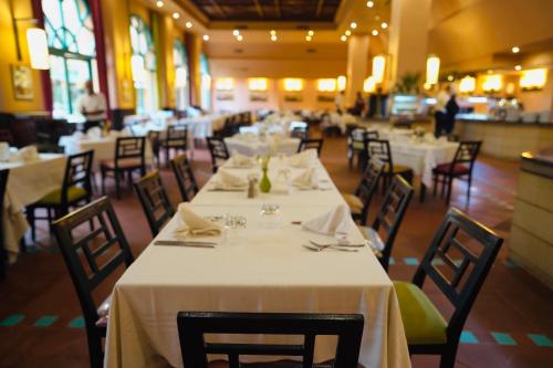 a dining room with white tables and chairs at Alhambra Thalasso in Hammamet