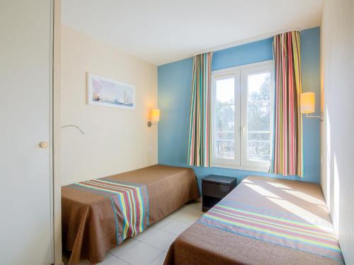 une chambre d'hôtel avec deux lits et une fenêtre dans l'établissement Apartment Les Marines-7 by Interhome, à La Foux