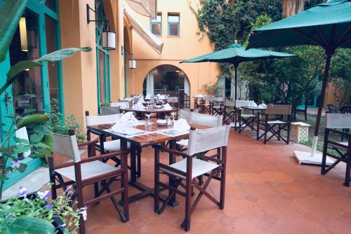 an outdoor restaurant with tables and chairs and umbrellas at Alhambra Thalasso in Hammamet