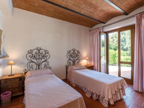 a bedroom with two beds and a large window at Villa La Gattaiola Piccola by Interhome in Montemerano
