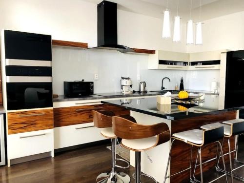 a kitchen with a counter and some chairs in it at Family Flat in the heart of Senec in Senec