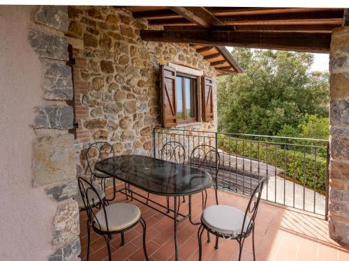 a patio with a table and chairs on a balcony at Villa La Gattaiola Piccola by Interhome in Montemerano