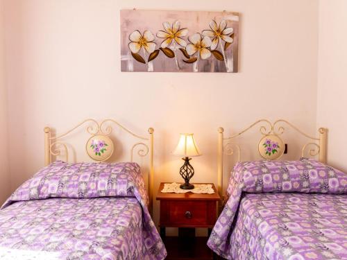 a bedroom with two beds and a picture on the wall at Holiday Home La terrazza sulla Maremma by Interhome in Scansano