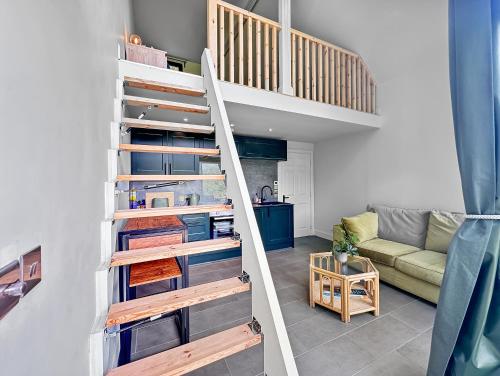 a staircase in a living room with a couch at Aos Sí - Wellness - Jacuzzi - Lodges in Ballachulish