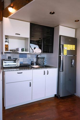 a kitchen with white cabinets and a refrigerator at The Domes Jarabacoa in Jarabacoa
