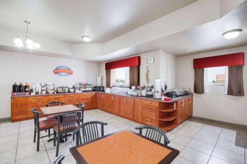 a large kitchen with wooden cabinets and a table and chairs at Baymont by Wyndham Wheeler in Wheeler