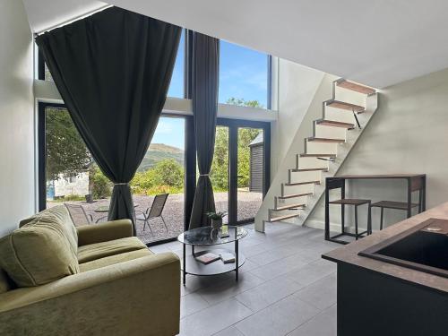 a living room with a couch and a staircase at Aos Sí - Wellness - Jacuzzi - Lodges in Ballachulish