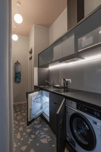 a kitchen with a washer and a washing machine at Resume apartments in Kaunas