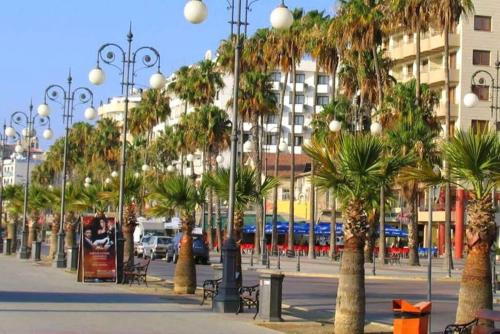 a city street with palm trees and street lights at AirBnSea City Centre Side Sea view Apartments in Larnaca
