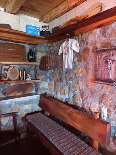 un mur en pierre avec un banc dans une pièce dans l'établissement Kuća za odmor Vidikovac, à Rumboci