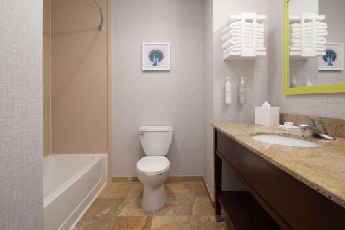 a bathroom with a toilet and a tub and a sink at Hampton Inn and Suites Seattle - Airport / 28th Avenue in SeaTac