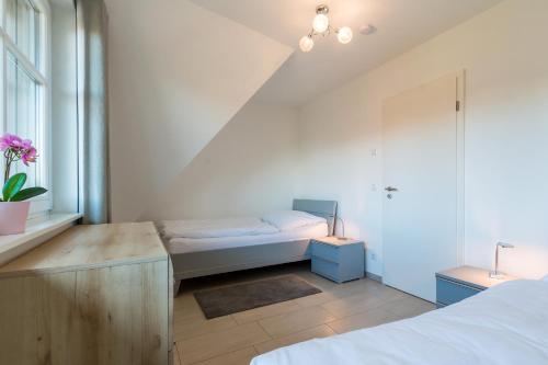 ein weißes Schlafzimmer mit einem Bett und einem Fenster in der Unterkunft An den Eichen 1 in Wieck