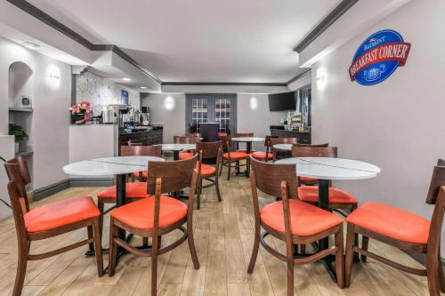 ein Restaurant mit Tischen und Stühlen und einer Küche in der Unterkunft Baymont by Wyndham Austin University Area in Austin