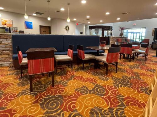 a dining room with a table and chairs on a carpet at Comfort Suites Altoona North in Altoona