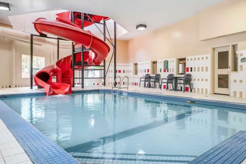 a indoor swimming pool with a red slide at Quality Inn Airport in Moncton