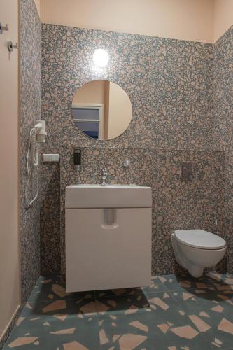 a bathroom with a toilet and a sink and a mirror at Resume apartments in Kaunas