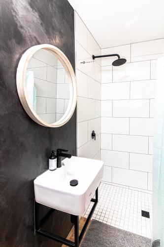 a bathroom with a white sink and a mirror at Modern Cabin in Malkerns in Malkerns