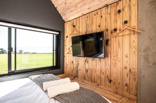 a bedroom with a bed and a tv on a wall at Modern Cabin in Malkerns in Malkerns
