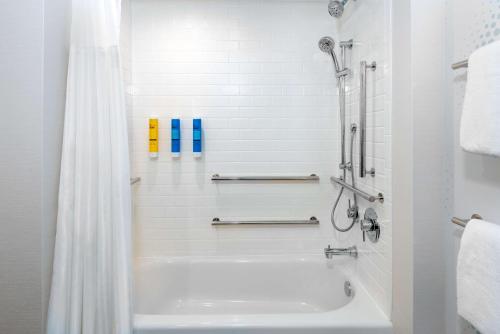 a white bathroom with a tub and a shower at Tru By Hilton Wilmington in Wilmington