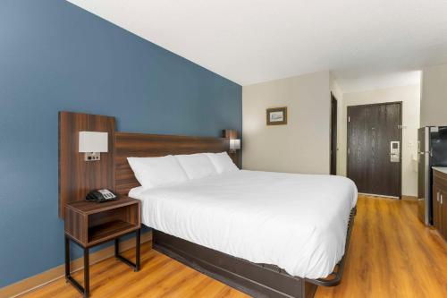 a bedroom with a large bed and a television at Suburban Studios LaVale - Cumberland in La Vale
