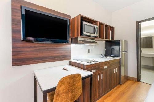 a small kitchen with a desk and a tv at Suburban Studios LaVale - Cumberland in La Vale