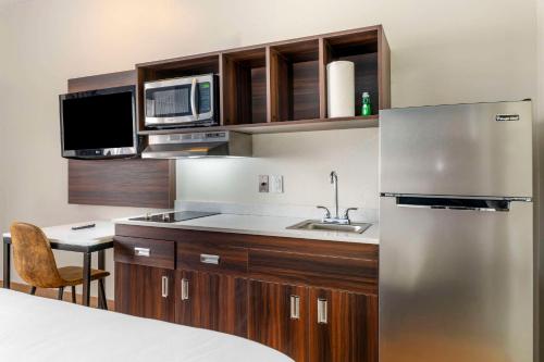 a kitchen with a stainless steel refrigerator and a microwave at Suburban Studios LaVale - Cumberland in La Vale
