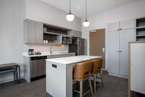a kitchen with a white counter and some chairs at Homewood Suites By Hilton Missoula in Missoula