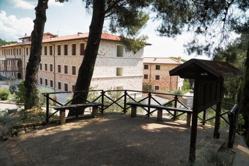a park with benches in front of a building at Domus Laetitiae Assisi in Assisi