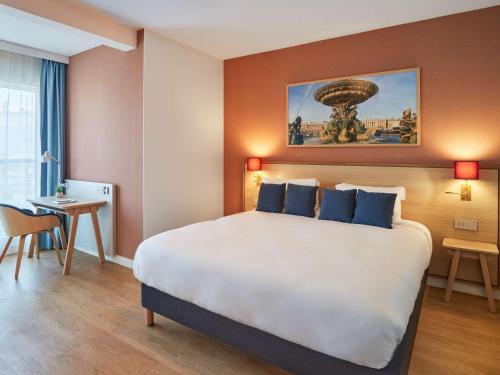 a hotel room with a large bed and a desk at Aparthotel Adagio Paris Boulogne in Boulogne-Billancourt