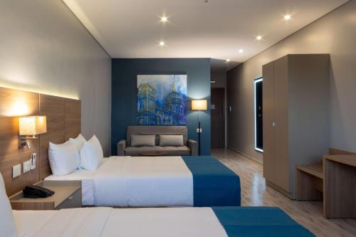 um quarto de hotel com uma cama grande e uma secretária em Tryp by Wyndham Asuncion em Assunção