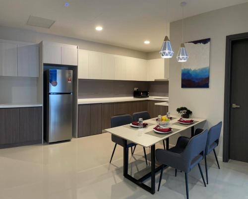 a kitchen with a table and chairs and a refrigerator at Suasana Suites Johor Bahru City Centre in Johor Bahru