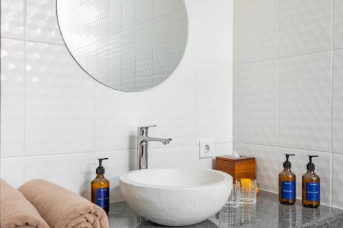 une salle de bains avec un lavabo blanc et un miroir dans l'établissement The Lavana Bliss One Villa Nyanyi Beach, à Canggu