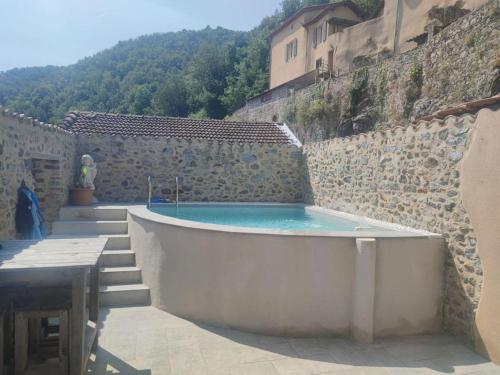 une baignoire installée au-dessus d'un mur en pierre dans l'établissement maison en pierre, à Vion