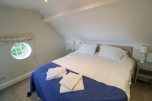 a bedroom with a large white bed with a window at Bank House Longtown in Longtown