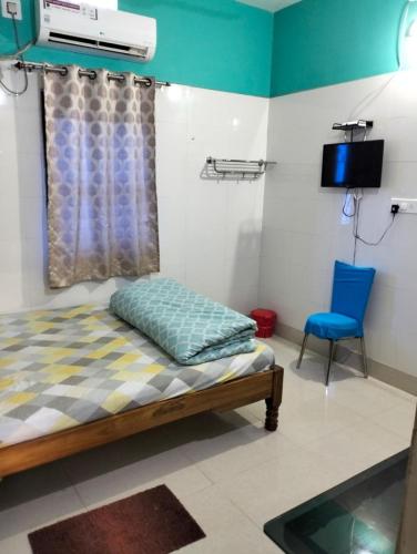 a bedroom with a bed and a blue chair at Okaasan Guest House in Konārka