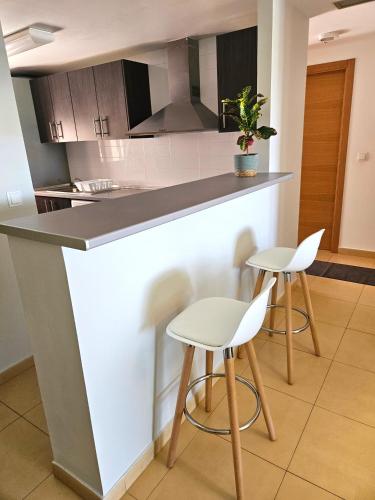 a kitchen with two stools and a counter top at Vista Del Sol in Murcia