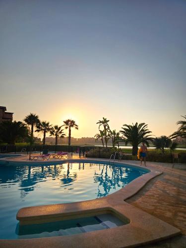 a large swimming pool with a sunset in the background at Vista Del Sol in Murcia