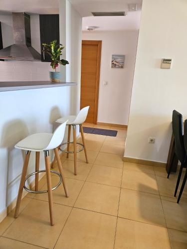 a kitchen with two white chairs and a table at Vista Del Sol in Murcia