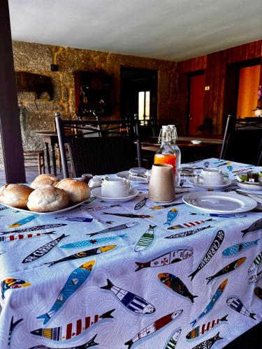 a table with a table cloth with food on it at QG Quinta de Grovelas in Balança