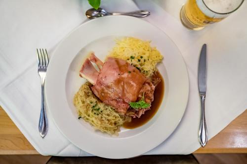 a plate of food with meat and rice on a table at Ruhpoldinger Hof - Hotel & Wellness in Ruhpolding