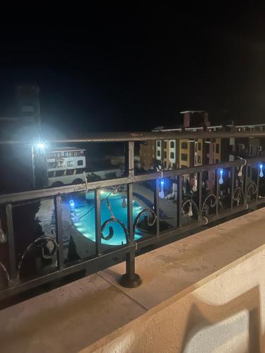 a black fence with lights in front of buildings at night at Аpartments Comfort -Marina Cape in Aheloy