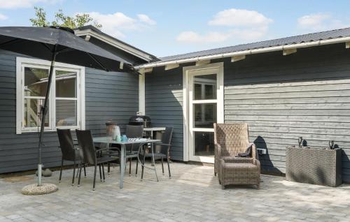 a patio with a table and chairs and an umbrella at 3 Bedroom Lovely Home In Skjern in Skjern