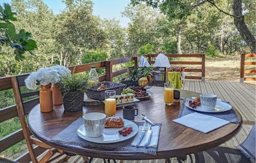 a wooden table with food and drinks on a deck at Amazing Home In La Garde-Freinet in La Garde-Freinet