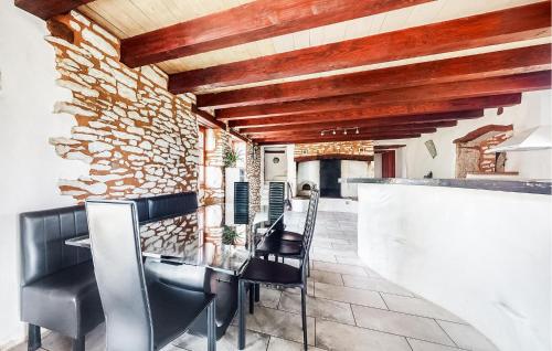 un bar avec des chaises noires et un mur en pierre dans l'établissement 4 Bedroom Pet Friendly Home In Carlucet, à Carlucet