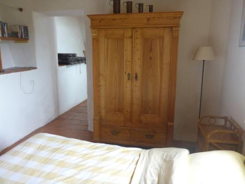 プラ・ド・モロ・ラ・プレストにあるMas Taillet Le Cameliaのベッドルーム(木製キャビネット、ベッド付)