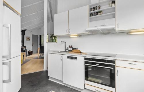 a kitchen with white cabinets and a stove top oven at 3 Bedroom Lovely Home In Otterup in Otterup